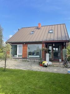 a small house with a large window in a yard at Upes lillijas in Jelgava