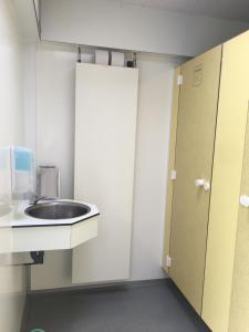 a bathroom with a sink and a door at Camping Suderse - De Protter in Workum +1 photo