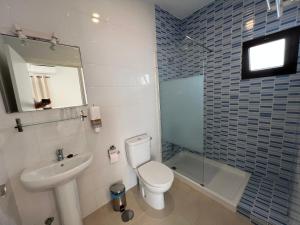 a bathroom with a toilet and a sink and a shower at Hostal Rios in Bolonia