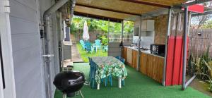 an outdoor kitchen with a table and chairs on a house at Escale Terre Rouge in Saint-André