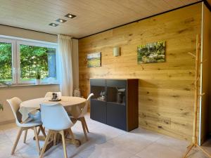 a dining room with wooden walls and a table and chairs at Ferienwohnung Sattler in Mistelgau