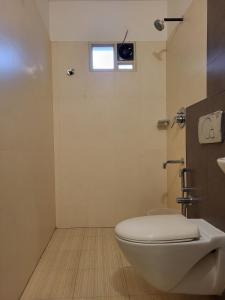 a bathroom with a toilet and a window at Hotel Grand Vista in Cochin