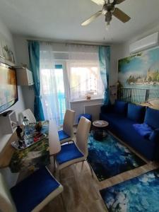 a living room with a blue couch and a table at Riviera Apartman in Hajdúszoboszló