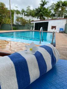 a towel with a white flower on top of a swimming pool at White Bridge House & Resort in Aluthgama