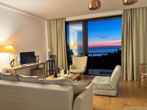 a living room with white furniture and a large window at Sea View Private Villa in Batumi