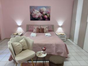 a bedroom with a pink bed and a chair at Domus Lucrezia in Bisceglie