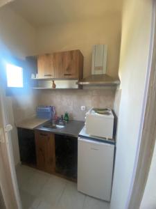 a small kitchen with a sink and a refrigerator at Eleftheria House in Vourvourou +12 photos
