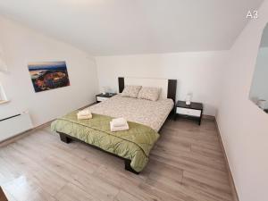 a bedroom with a bed with two towels on it at Apartments Bardak in Ližnjan