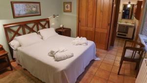 a bedroom with a bed with towels on it at Casa Piñeiro in Monfero