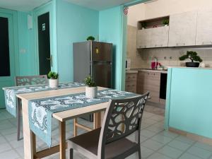a kitchen with a table and chairs and a refrigerator at Domus Lucrezia in Bisceglie
