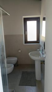 a bathroom with a sink and a toilet and a window at Oasi 29 in Morlupo