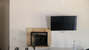 a flat screen tv on a wall with a fireplace at Oasi 29 in Morlupo
