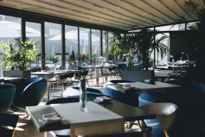 an empty restaurant with tables and chairs and windows at Przystań Hotel&Restaurants in Olsztyn