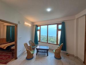 a room with chairs and a table and a window at Nashala View Homestay in Nagar