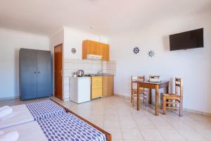 a kitchen with a refrigerator and a table with a tablektop at Giota's Studio in Karpathos