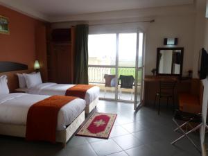 um quarto de hotel com duas camas e uma varanda em Hotel Arena Fes em Fez