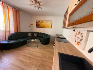 a living room with a black couch and a table at 3 bedroom Apartman Izolana in Izola