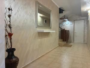 a hallway with a vase and a mirror on a wall at Guest rooms Marina in Obzor +52 photos