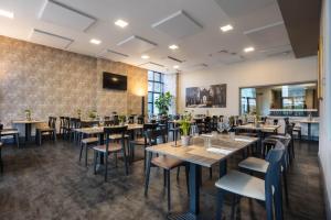 a restaurant with tables and chairs and a wall at iH Hotels Milano Lorenteggio in Milan +39 photos