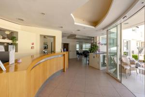 an office lobby with a long counter and chairs at Hotel Man in Lido di Savio