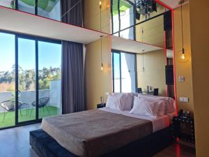 ein Schlafzimmer mit einem großen Bett und großen Fenstern in der Unterkunft Motel Século in Lousada