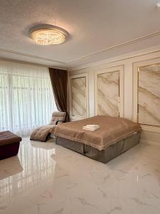 a bedroom with a large bed and a ceiling at Mirali Resort in Almaty +50 photos