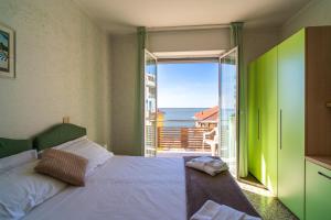 a bedroom with a bed and a view of the ocean at Hotel Corallo in Pietra Ligure