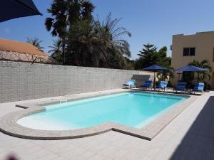 a large swimming pool with chairs and umbrellas at Dandimayo Hotel Bar & Restaurant in Serekunda +9 photos