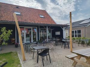 a patio with tables and chairs and tables and a building at Granny's B&B in Kapelle