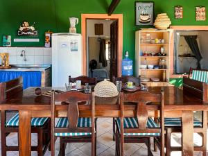 a dining room with a table with chairs and a refrigerator at Loft NOA'House in Canoa Quebrada