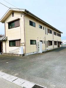 a building with a parking lot in front of it at 田園の宿 in Takehanachō