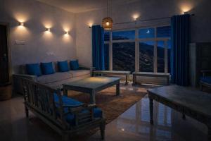 a living room with a couch and a table at Sky Mount Villa in Mount Ābu +41 photos