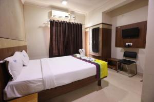 a hotel room with a bed and a television at Hotel BCP Suites in Bangalore