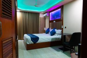 a bedroom with a bed and a desk and a tv at Six In Lodge in Male City
