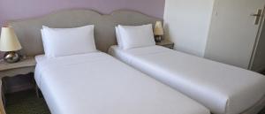 two beds in a hotel room with white sheets at Hôtel Ikar Blois Sud in Saint-Gervais-la-Forêt +22 photos