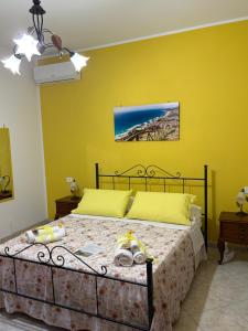 a bedroom with a bed with a yellow wall at La casa di Nonna Anna in Castellabate
