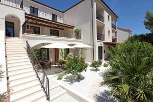 an external view of a house with tables and umbrellas at Casa Serena Bol in Bol
