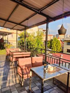 a patio with tables and chairs on a roof at Bhandari hotel and sekuwa corner in Pashupatināth