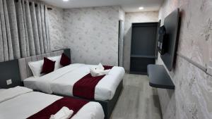 a hotel room with two beds and a television at Bhandari hotel and sekuwa corner in Pashupatināth