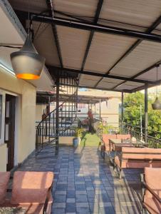a patio with benches and tables and a person on a bike at Bhandari hotel and sekuwa corner in Pashupatināth +11 photos