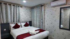 a bedroom with a large bed with red and white pillows at Bhandari hotel and sekuwa corner in Pashupatināth