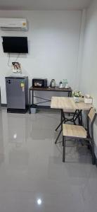 a room with a table and chairs and a television at TR Hotel Udon Thani in Ban Dong Kheng +8 photos