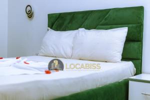 a white bed with a logo on top of it at Casa-Branca Pelundo in Rufisque