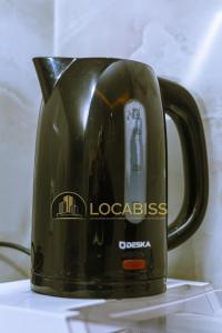a black coffee pot is sitting on a table at Casa-Branca Pelundo in Rufisque