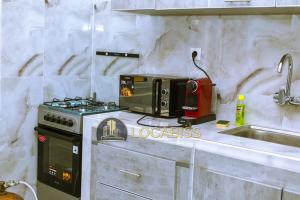 a kitchen with a stove and a microwave on a counter at Casa-Branca Pelundo in Rufisque