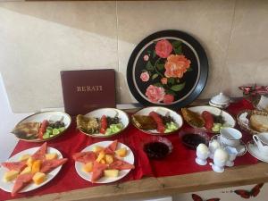 a table with plates of food on a red table cloth at Xhulio Guesthouse Berat in Berat +26 photos