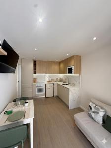 a kitchen and living room with a table and a couch at Vila Sotto Mayor in Figueira da Foz