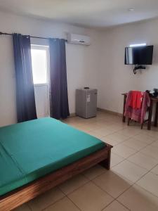 a room with a bed and a television in it at Hotel Bartaba in Antsiranana