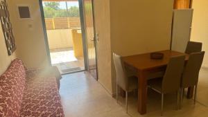 a dining room with a wooden table and chairs at TETRAKTYS ESTATE beachside seaview ΥΔΩΡ with big garden in Halikounas