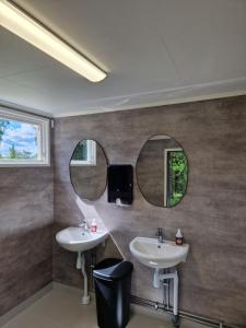 a bathroom with two sinks and two mirrors at Långseruds Stugby Nature Cabins in Byn